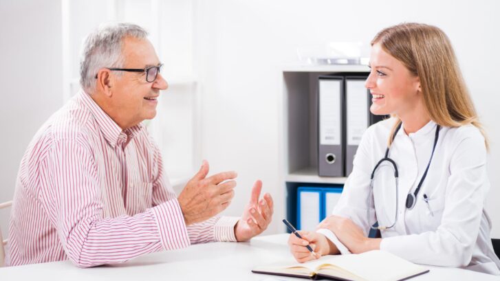 Doctor listening to a happy patient in her office.