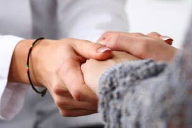 A doctor holding a patients hands